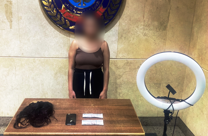 المتهمة و أمامها المضبوطات 