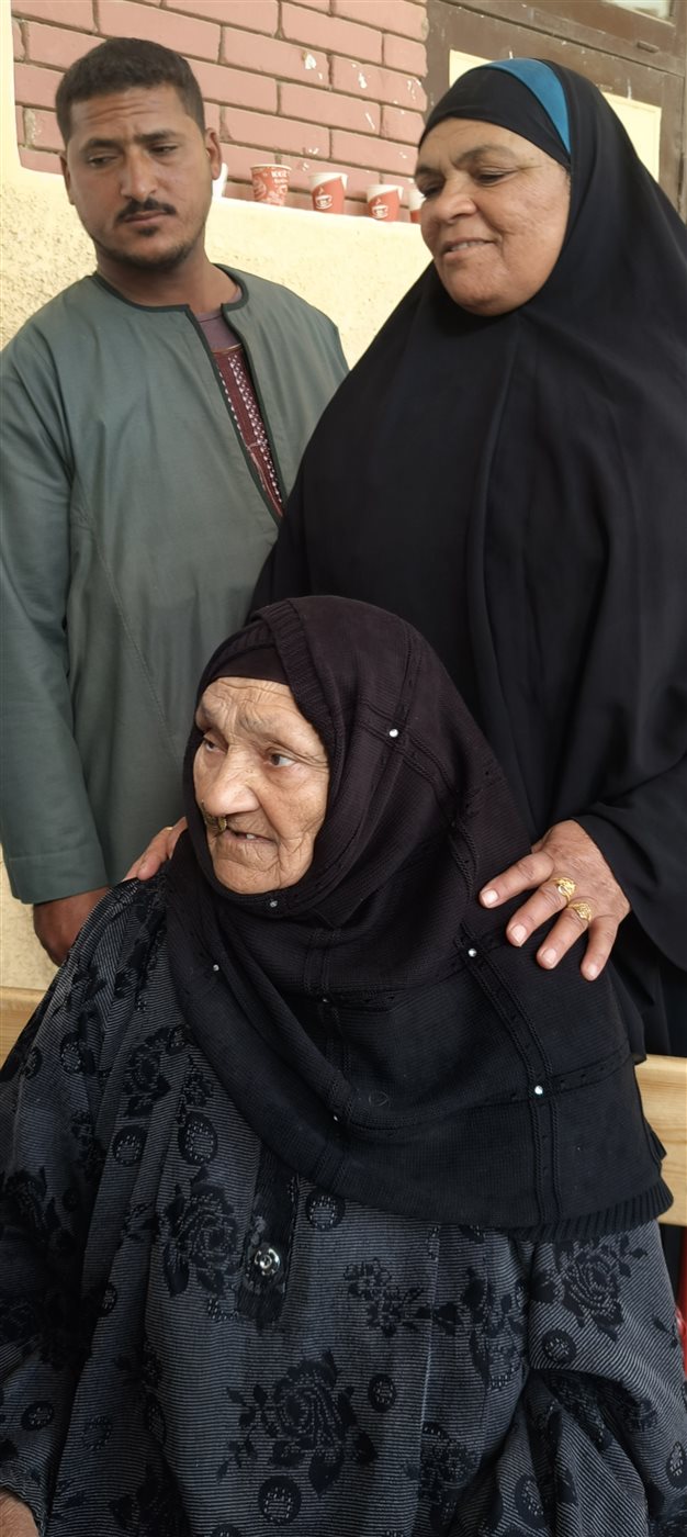 مسنة عمرها 85 عامًا على كرسي متحرك تتحدى المطر للإدلاء بصوتها في لجنة مدرسة اللواء أحمد عبد التواب بطامية