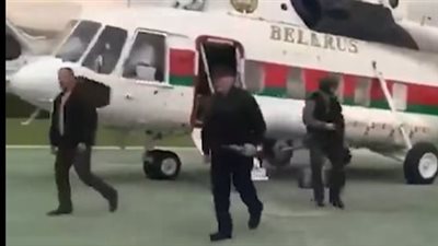 مشهد لافت.. رئيس بيلاروسيا يهبط من الطائرة حاملا بندقية آلية