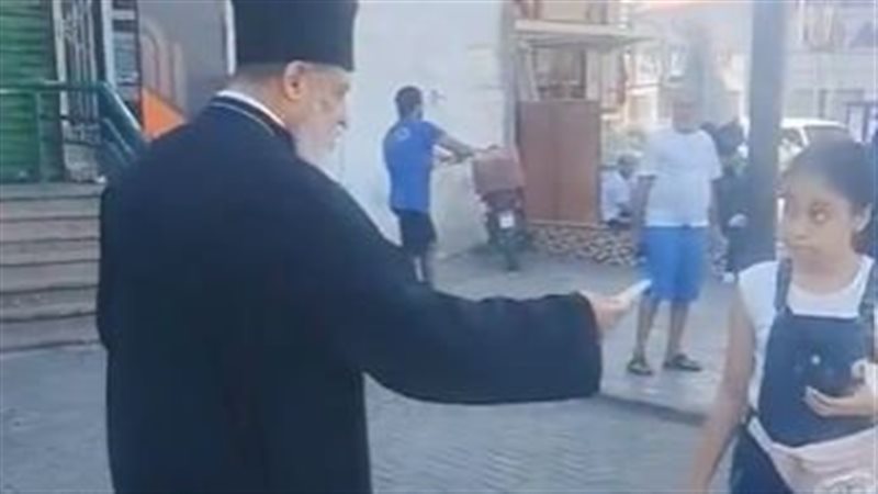 قس يوزع حلوى المولد