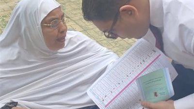 قاضٍ يساعد مسنة على الإدلاء بصوتها داخل لجنة بإيتاى البارود 