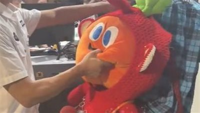 مسافر يحمل حقيبة على شكل دمية يثير الضحك بعد تمريرها عبر جهاز التفتيش