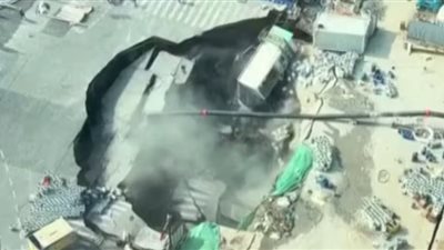 حفرة ضخمة تبتلع طريق وجزء من موقع بناء في وسط مدينة شنجهاي