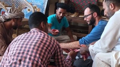سائح إيطالي يترك الدراجة ويحمل شنطة اللحمة.. مشاركة في توزيع الأضاحي بالأقصر
